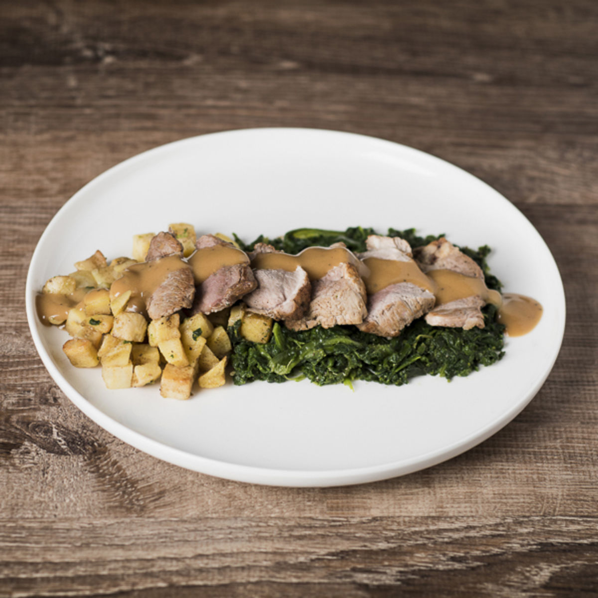 Pork tenderloin, spinach and fried potatoes with pepper sauce